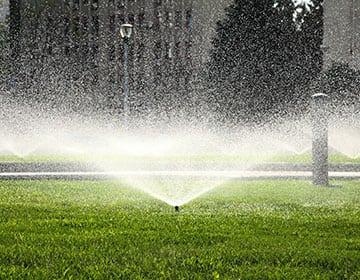 Sprinkler heads watering a healthy lawn