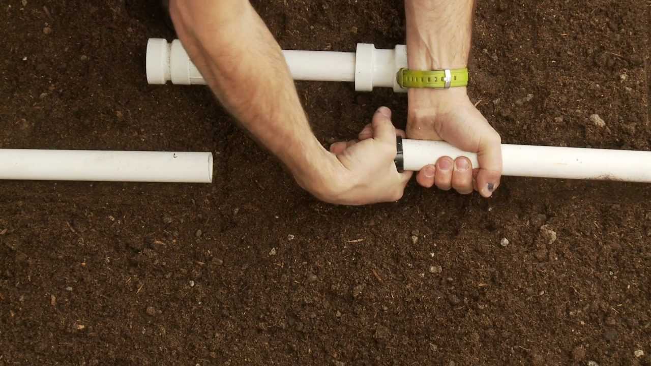 Hands joining PVC irrigation pipe during a line repair